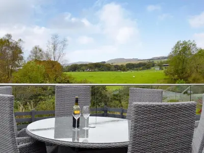 a glass of wine sitting on a table on a patio at Thistlebank in Banknock