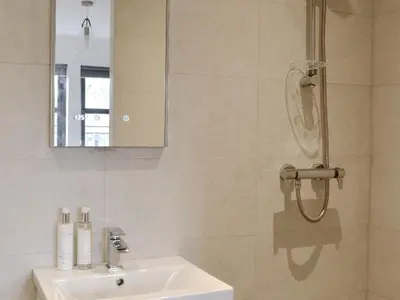 a bathroom with a sink and a mirror and a shower at Thistlebank in Banknock