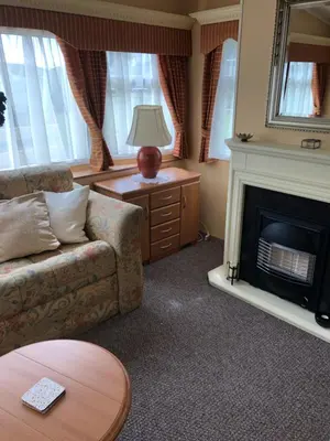 a living room with a couch and a fireplace at 40 Glenfinart Caravan Park in Dunoon
