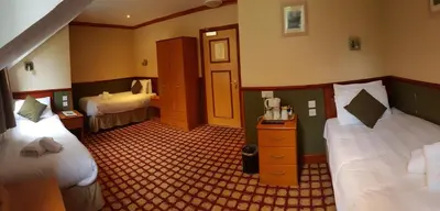 a hotel room with two beds and a telephone in it at Clachaig Inn in Ballachulish