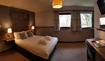 a bedroom with a bed with two towels on it at Clachaig Inn in Ballachulish