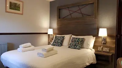 a hotel room with a bed with towels on it at Clachaig Inn in Ballachulish