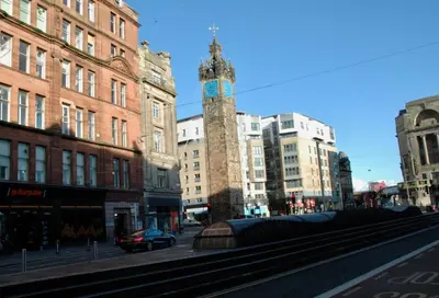 a city street with a clock tower and buildings at The Socair - Bright Contemporary Merchant City Flat in Central Location in Glasgow