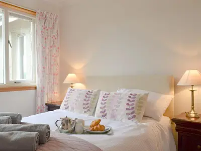 a bedroom with a bed with a tray of food on it at Dunyvaig in Colintraive