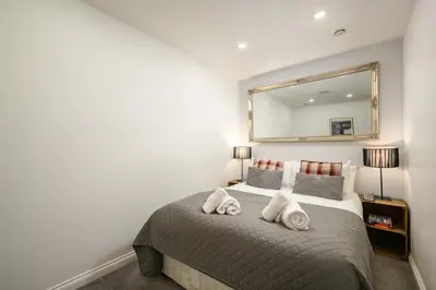 a bedroom with a bed with a mirror on the wall at Stylish & Central 2BR Stockbridge Gem in Edinburgh