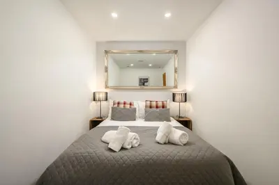 a bedroom with a large bed with a large mirror at Stylish & Central 2BR Stockbridge Gem in Edinburgh