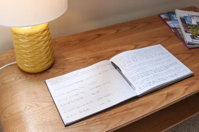 an open book on a table next to a lamp at Lochview Guesthouse in Corran