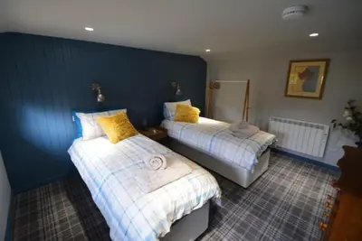 a bedroom with two beds with yellow pillows at Craiglockhart Lodge in Edinburgh