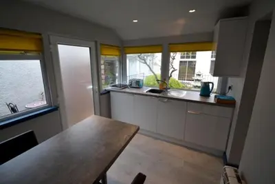 a kitchen with a table and some windows at Craiglockhart Lodge in Edinburgh