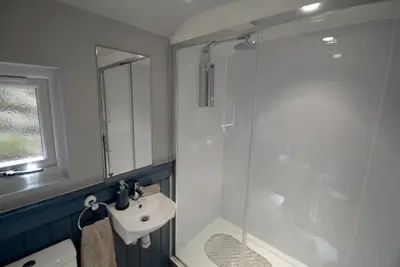 a white bathroom with a sink and a shower at Craiglockhart Lodge in Edinburgh
