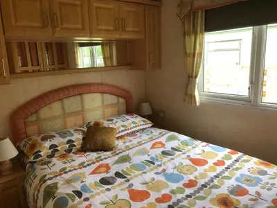 a bedroom with a bed with a comforter on it at Bermuda 29 in Dunoon