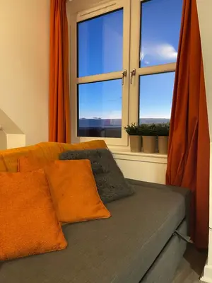 a bedroom with a bed and a window with orange curtains at Carvetii - Edward House D - 2 Dbl bed 2nd floor flat in Dunfermline