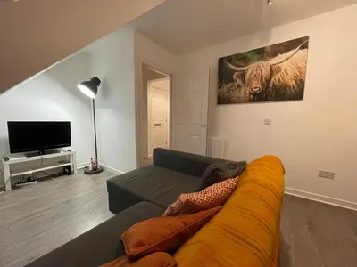 a living room with a couch and a television at Carvetii - Edward House D - 2 Dbl bed 2nd floor flat in Dunfermline