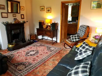 a living room with a couch and a fireplace at Argyllholidaycottage Loch Awe in Eredine