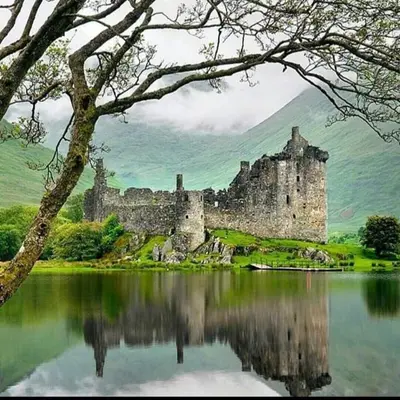 a castle sitting on top of a body of water at Argyllholidaycottage Loch Awe in Eredine