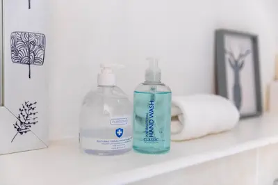 two bottles of water and a roll of toilet paper on a shelf at Merchant City Modern 1 Bed Executive Flat in Glasgow