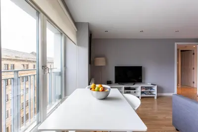 a living room with a table with a bowl of fruit on it at Merchant City Modern 1 Bed Executive Flat in Glasgow
