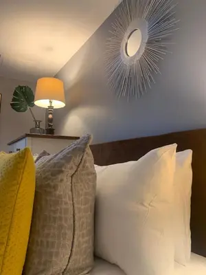 a bedroom with a bed with pillows and a mirror at Merchant City Modern 1 Bed Executive Flat in Glasgow