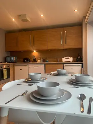 a kitchen with white bowls and plates on a table at Merchant City Modern 1 Bed Executive Flat in Glasgow
