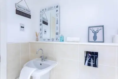 a white bathroom with a sink and a mirror at Merchant City Modern 1 Bed Executive Flat in Glasgow