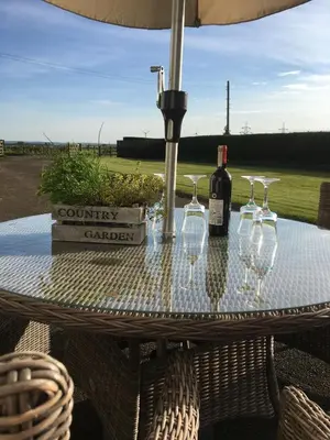 a table with glasses and a bottle of wine on it at South Doll Farm Cottage in Airth