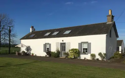 a white house with a black roof at South Doll Farm Cottage in Airth