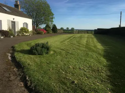 a field of grass next to a house at South Doll Farm Cottage in Airth