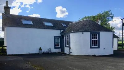 a white house with a black roof at South Doll Farm Cottage in Airth