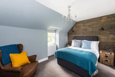 a bedroom with a bed and a chair at The Kilchrenan Inn in Oban