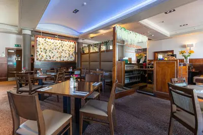 a dining room with wooden tables and chairs at Fletcher's Restaurant Bar & Rooms in Stirling