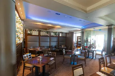 a restaurant with tables and chairs and a blue ceiling at Fletcher's Restaurant Bar & Rooms in Stirling
