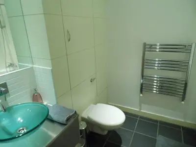 a bathroom with a blue sink and a toilet at Modern 2-bedroom Apt near SSE Hydro and SEC in Glasgow