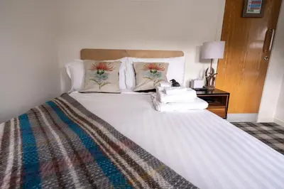 a bedroom with a large white bed with pillows at Cardross Inn in Cardross