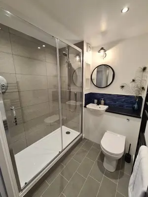 a bathroom with a shower and a toilet and a sink at Six Stevenson House, Oban in Oban