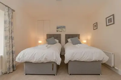 two beds sitting next to each other in a bedroom at Pant Farmhouse in Ayr