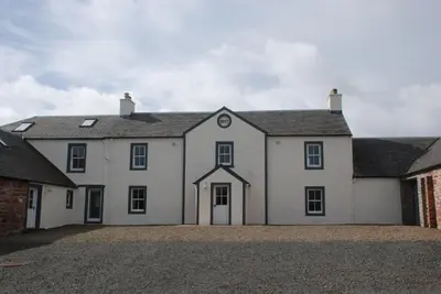 a large white house with a brick building at Pant Farmhouse in Ayr