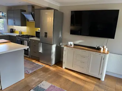 a kitchen with a stainless steel refrigerator and a tv at Kilmory Garden by the Loch in Lochgilphead
