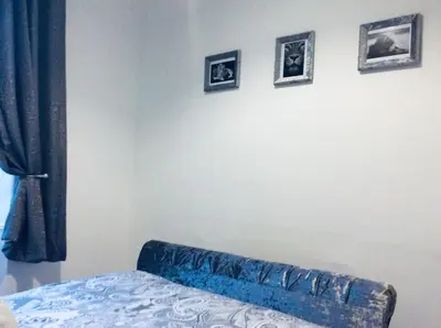 a bedroom with a bed and three pictures on the wall at THE LION'S DEN ON ROYAL STREET in Gourock