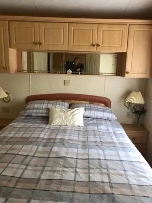a man taking a picture of a bed in a room at The Aspen 63 in Dunoon