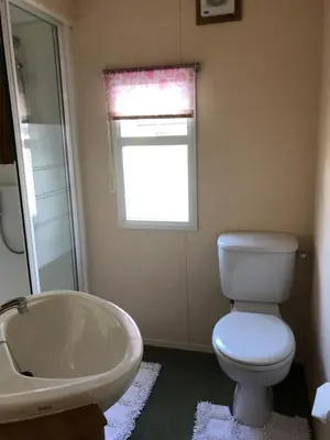 a bathroom with a tub and a toilet and a window at The Aspen 63 in Dunoon