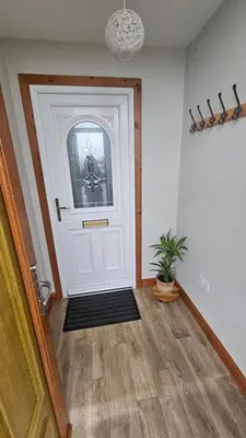 a hallway with a white door and a potted plant at Modern 1 bed Apartment close to Campbeltown in Campbeltown