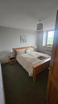 a bedroom with a large bed and a window at Modern 1 bed Apartment close to Campbeltown in Campbeltown