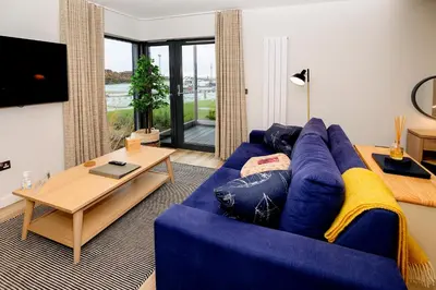 a living room with a blue couch and a table at The Salt Lodge in Troon
