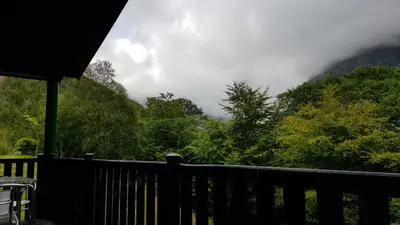 a wooden deck with a view of a mountain at Birch Chalet in Ballachulish