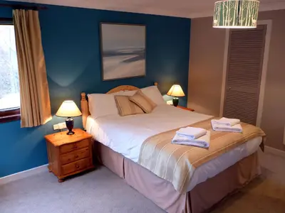 a bedroom with a bed with two towels on it at Oak Tree Lodge in Ballachulish