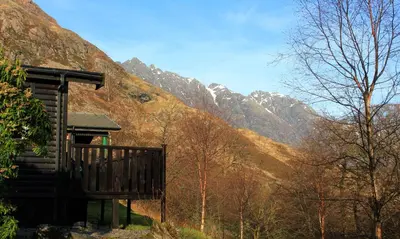 a cabin with a view of a mountain at Rowan Tree Lodge in Glencoe