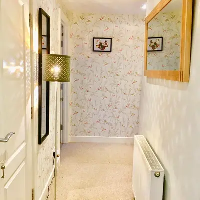 a hallway with a staircase with a pink wall at The Little Beech Tree in Linlithgow