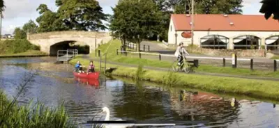 two people on a red boat in a river at The Little Beech Tree in Linlithgow