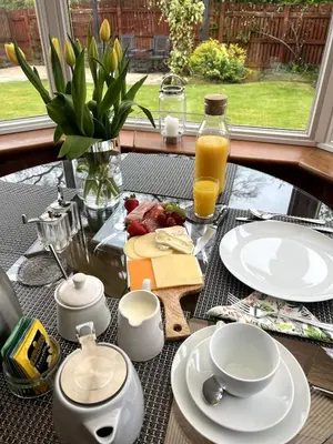 a table with plates of food and orange juice at Home2Home Meadow Close in East Kilbride