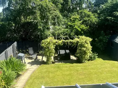 a garden with a gazebo and chairs in a yard at Home2Home Meadow Close in East Kilbride